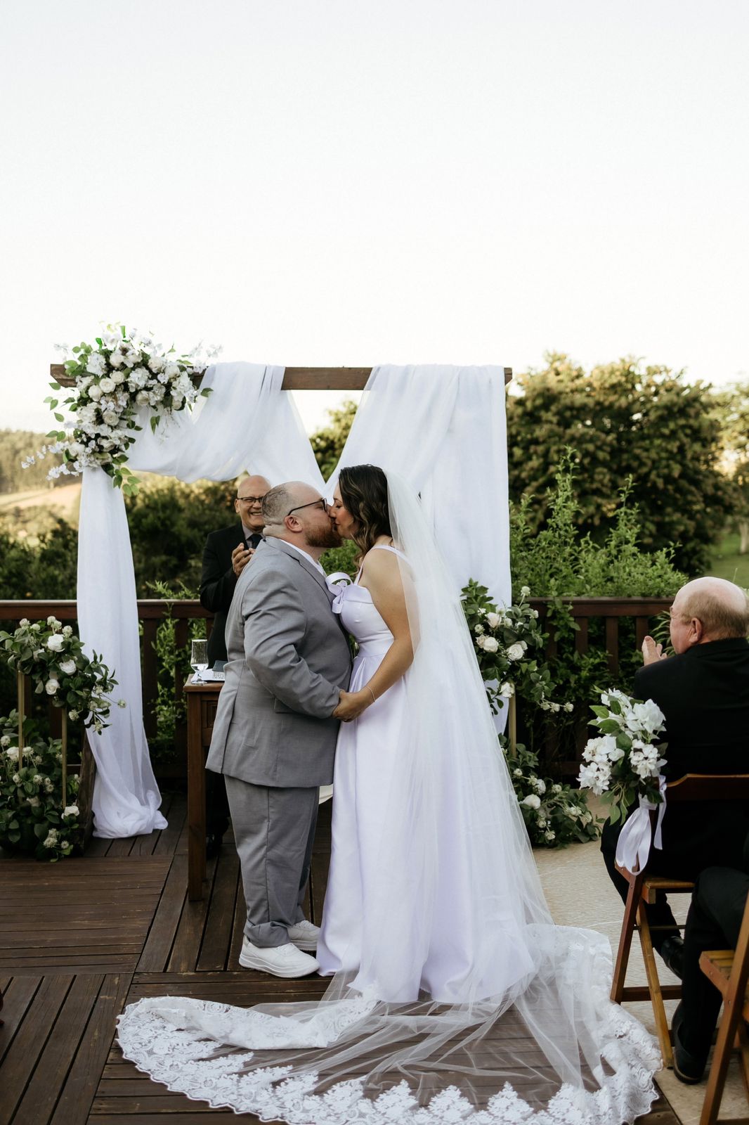 Noivos se beijando no altar ao ar livre
